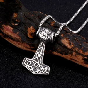 Thors Hammer Kette mit Knotenmuster im natürlichen Hintergrund mit Zweig, authentischer Wikingerschmuck