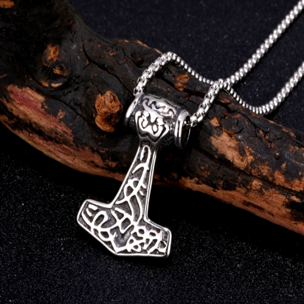 Thors Hammer Kette mit Knotenmuster im natürlichen Hintergrund mit Zweig, authentischer Wikingerschmuck