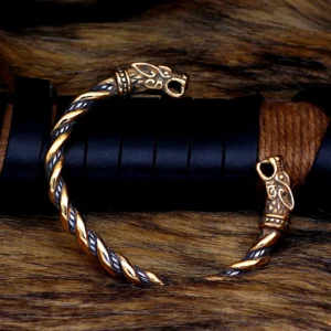 Wikinger Armreif goldener nordwolf mit wolfskopf design vor grauem hintergrund